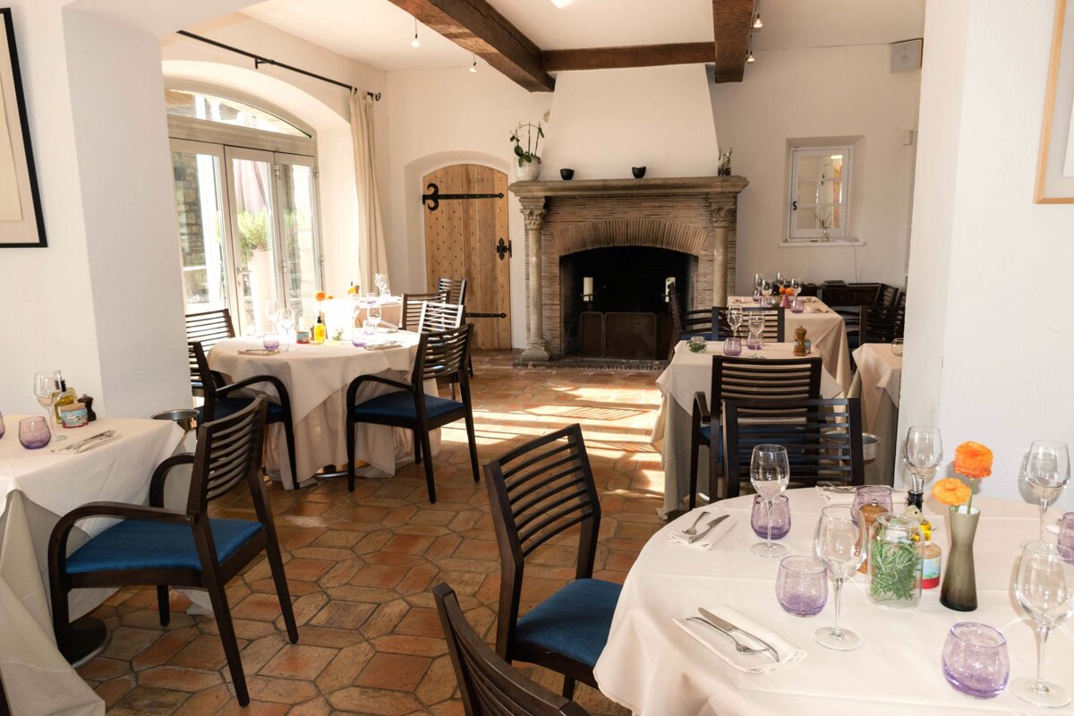 A dining room with tables and chairs and a fireplace