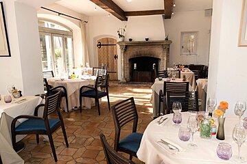 A dining room with tables and chairs and a fireplace
