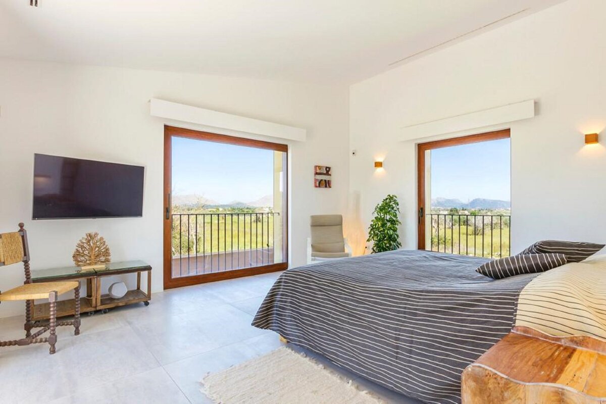 A bedroom with a large bed and a flat screen tv