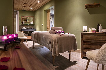 A massage table in a room with green walls