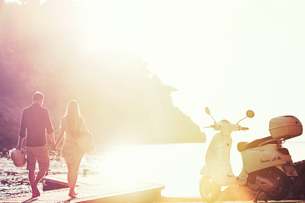 A couple on a pier with scooter in the background