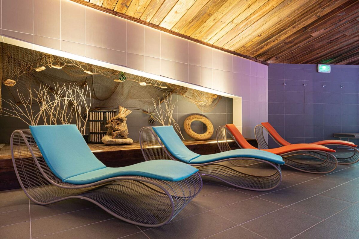 A row of lounge chairs in a room with a life preserver on the wall