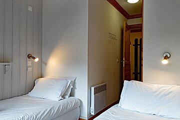 A small bedroom with two beds and a door
