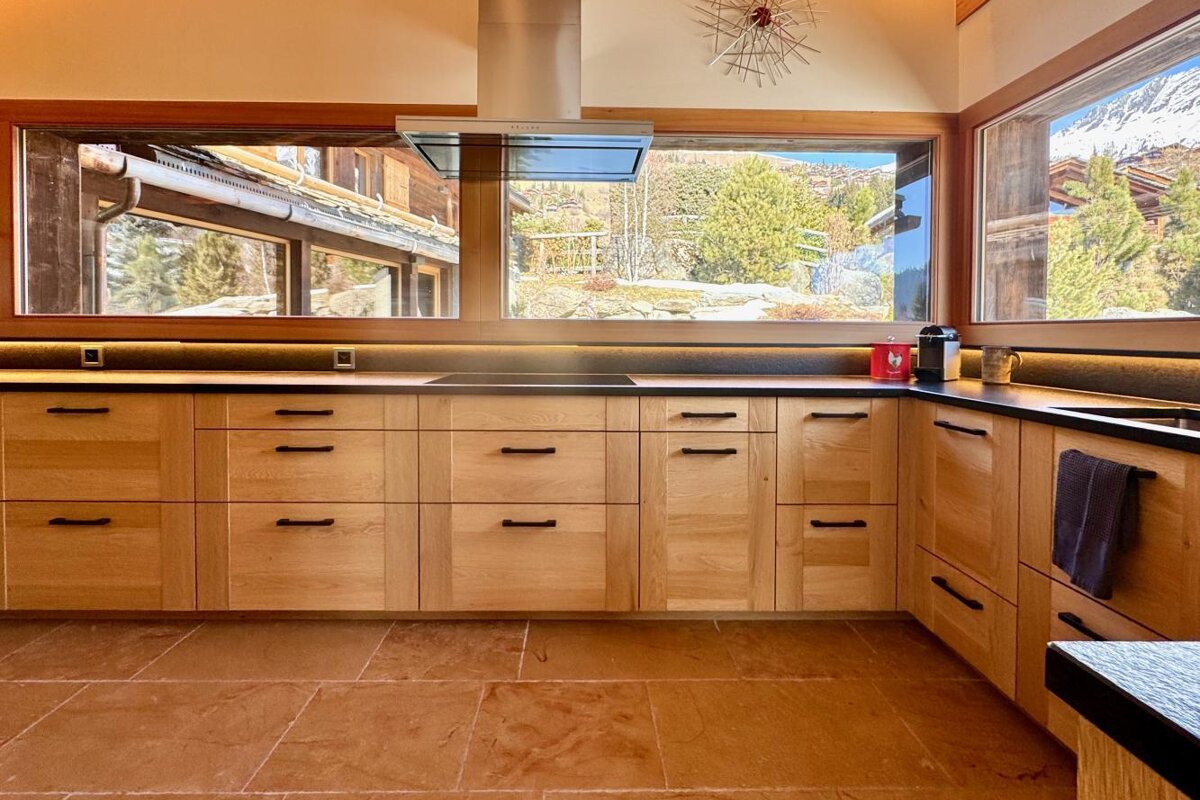 A kitchen with wooden cabinets and a large window