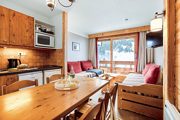 A kitchen with a microwave and a bottle of water on the table
