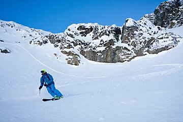 a skier in blue in the backcountry