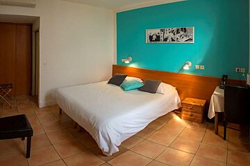 A hotel room with a blue wall and a bed