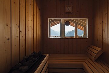 A wooden sauna with a window and a clock on the wall