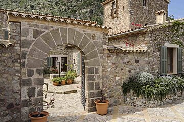 A stone archway leads to a stone building