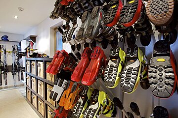 A bunch of ski boots are hanging on a wall