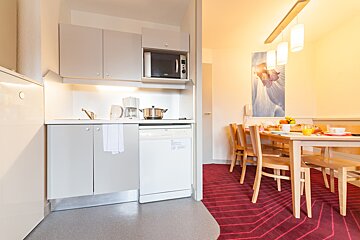 A kitchen with a table and chairs and a picture on the wall