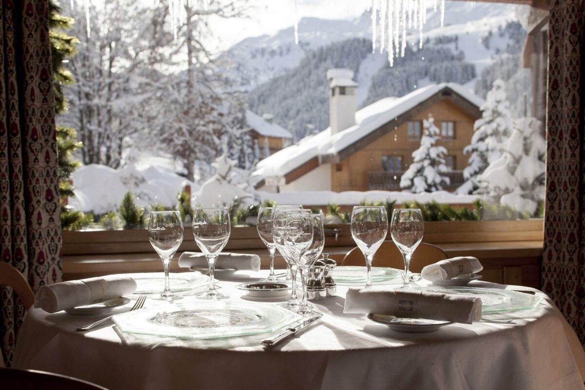 A table set for a meal with a view of snow covered mountains