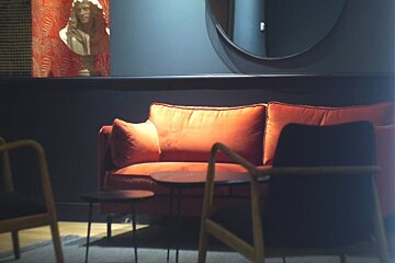 A couch in a room with a statue in the background