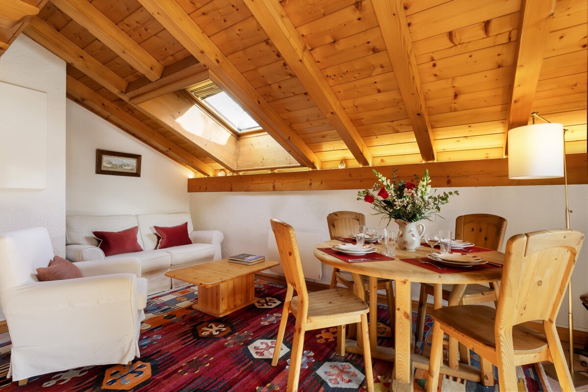 A living room with a wooden table and chairs