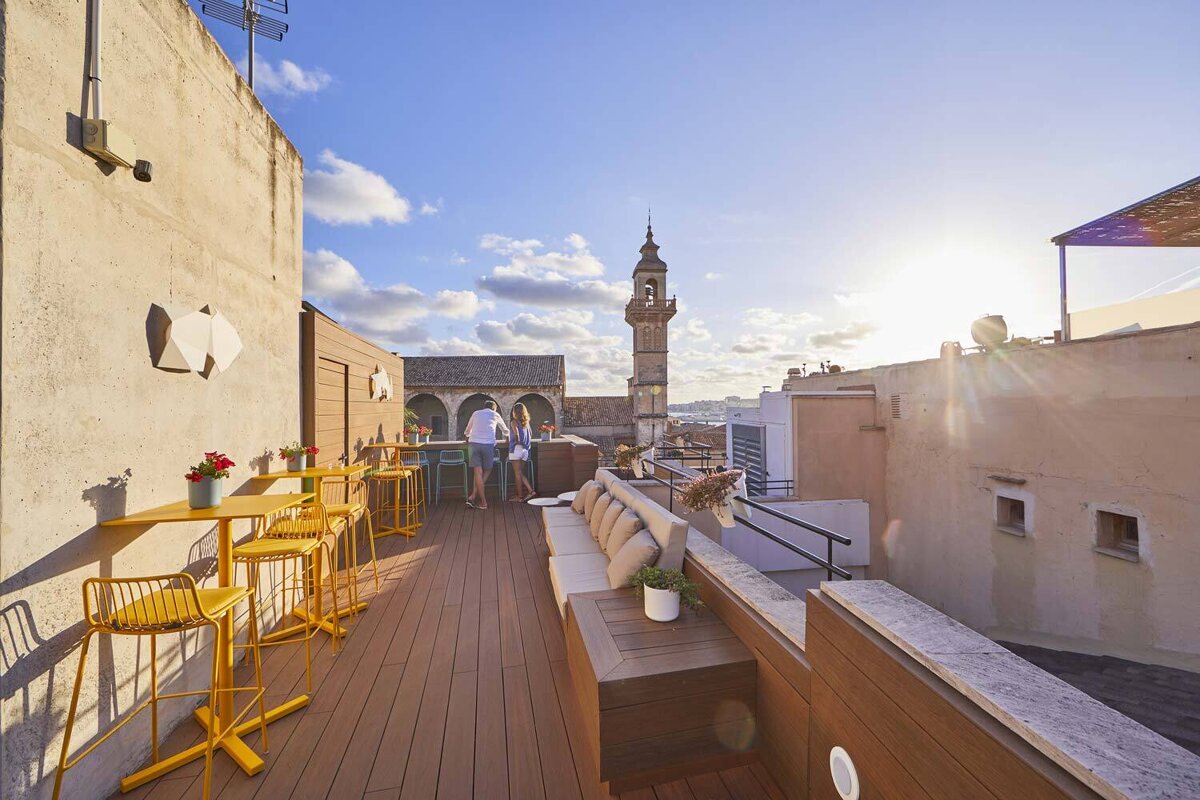 A couple standing on a balcony with a clock tower in the background