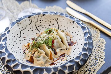 A bowl of food with sauce and sprouts on top