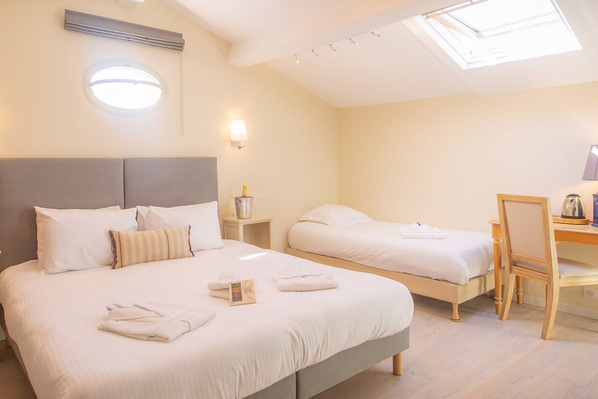 A hotel room with two beds and a desk