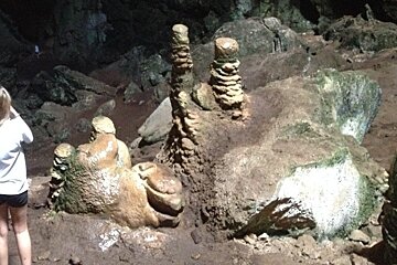 a girl stood next to cave formations in Mallorca