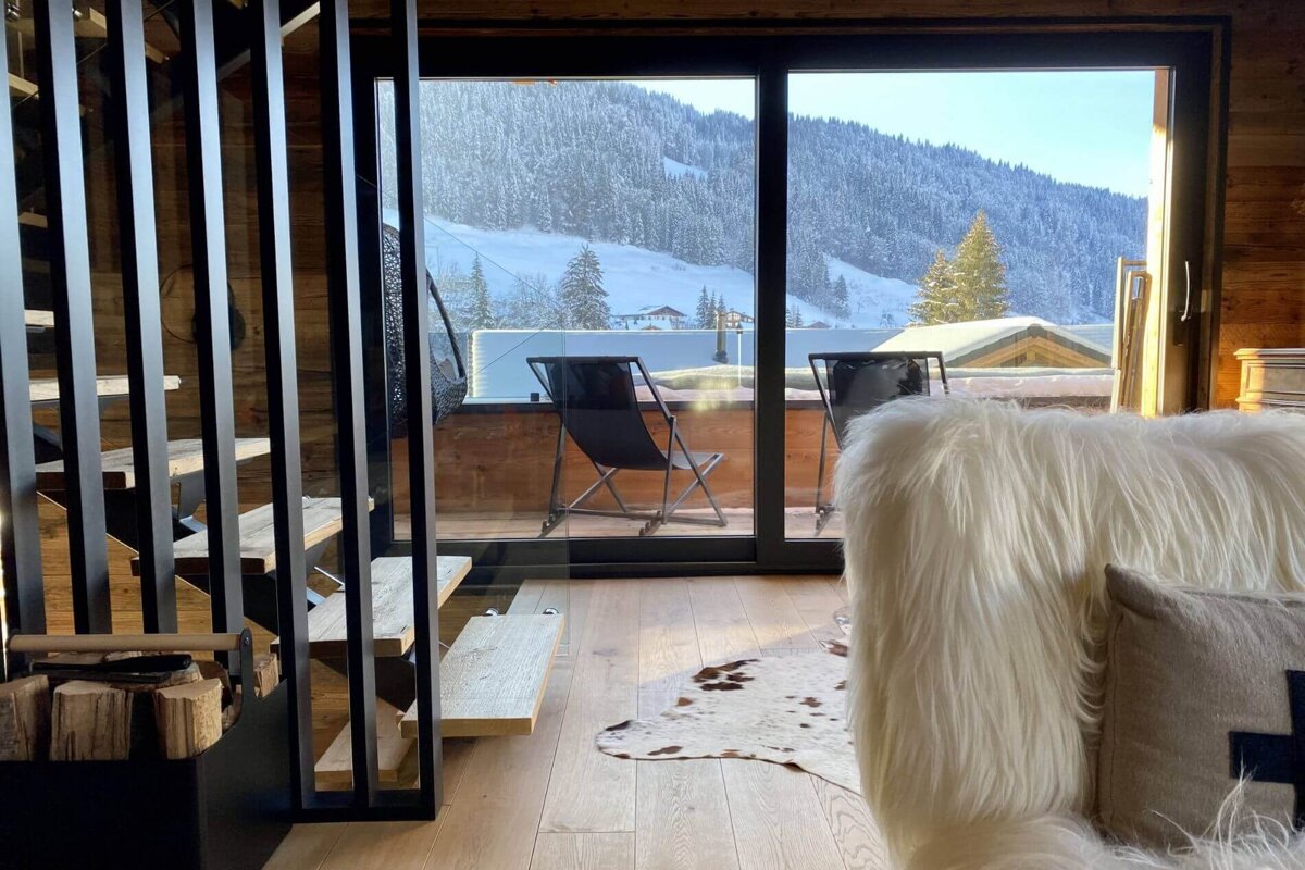 A living room with a view of a snowy mountain