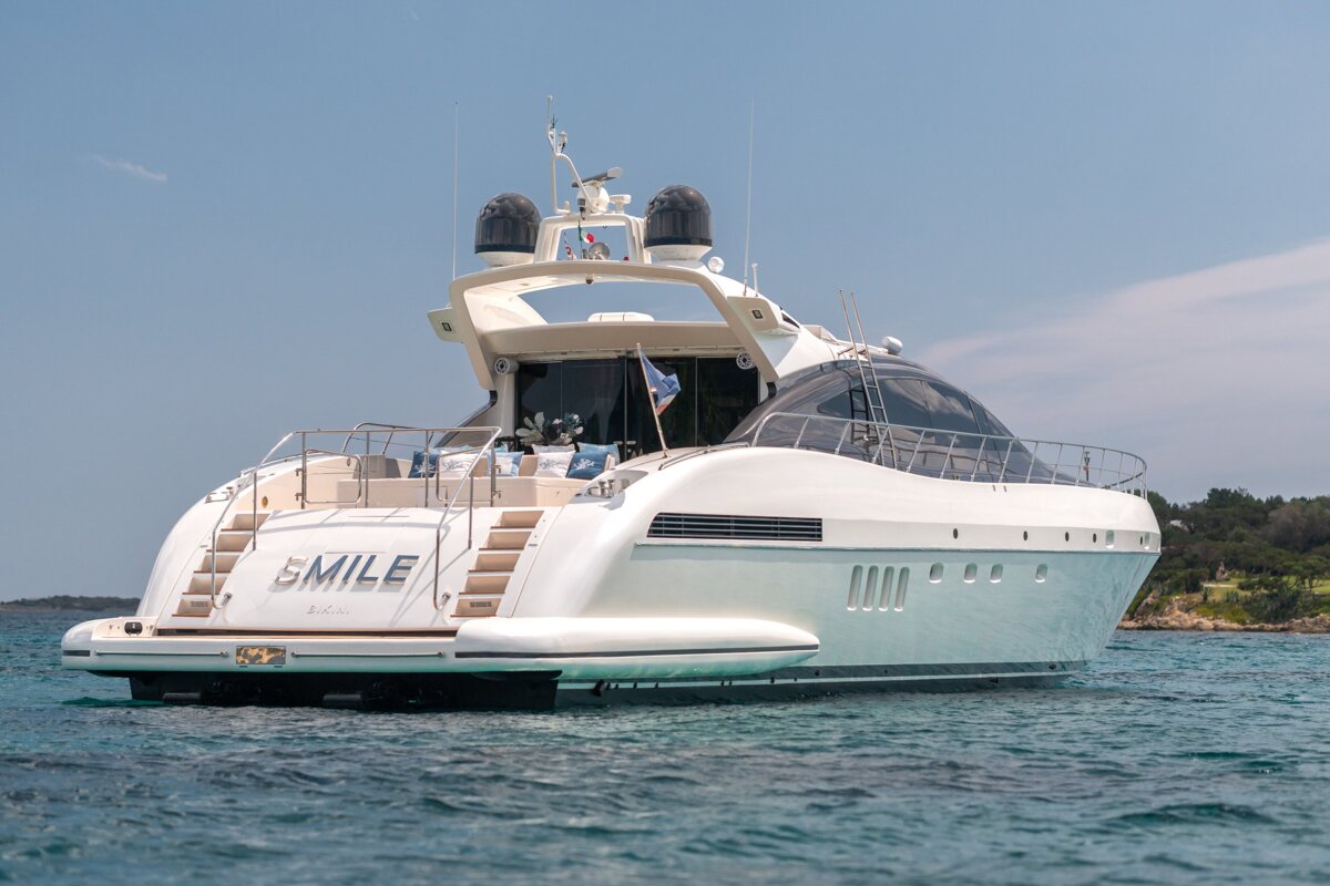 A large white yacht with the name smile on the back