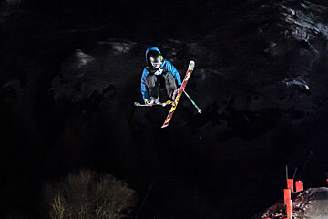 a skier jumping & crossing his skies