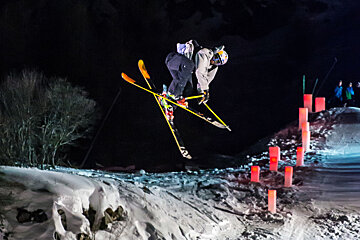 a skier doing a trick in a night competition
