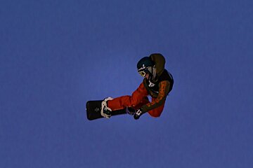 a snowboarder flying high over a jump