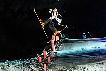 a skier with his legs split mid air