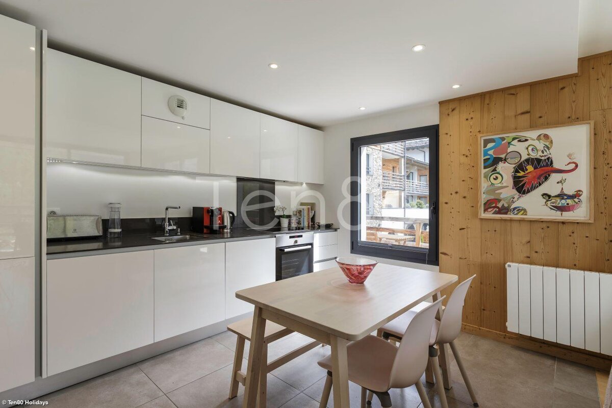 A kitchen with a table and chairs and a picture on the wall that says holidays