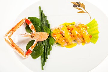 A white plate with a shrimp and green beans on it