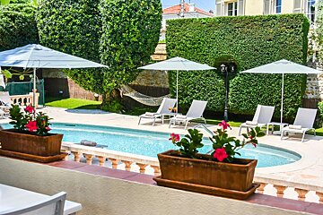 A swimming pool surrounded by chairs and umbrellas