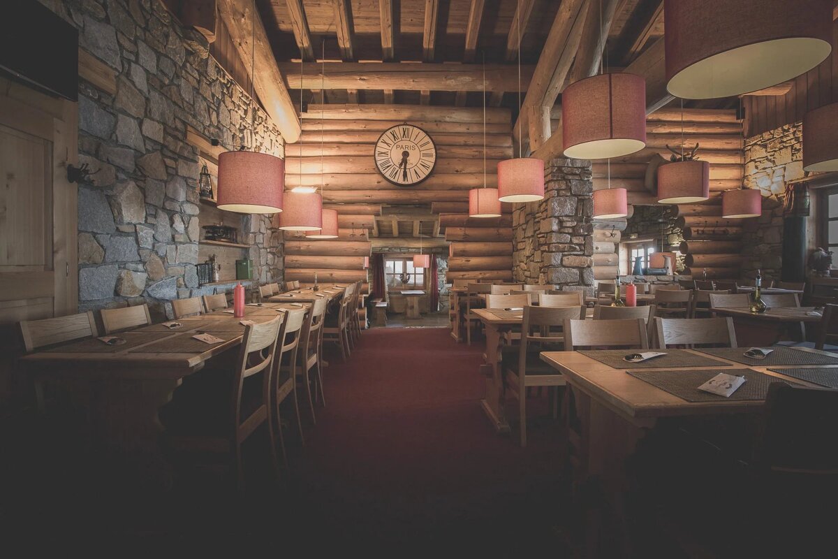A restaurant with tables and chairs and a clock on the wall