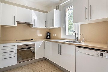 A kitchen with white cabinets and a bosch dishwasher