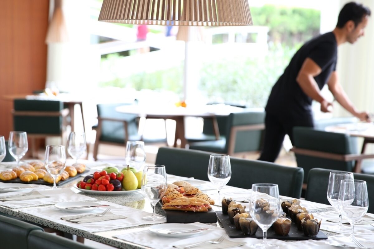 A waite laying out the restaurant in the sports centre of palma
