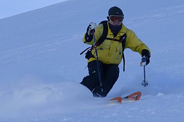 a skier in a yellow jacket