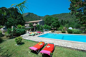 A large swimming pool with a house in the background