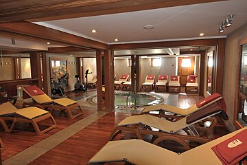 A row of lounge chairs in a room with a hot tub