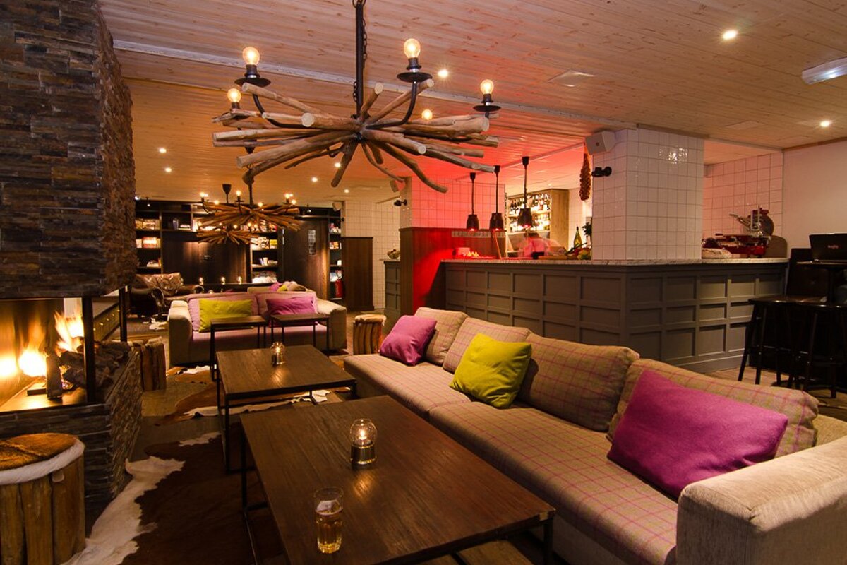 A couch with purple pillows sits in front of a fireplace