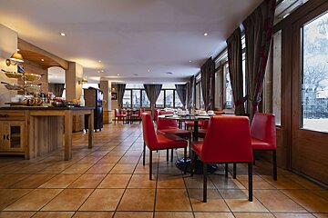 A dining room with red chairs and tables