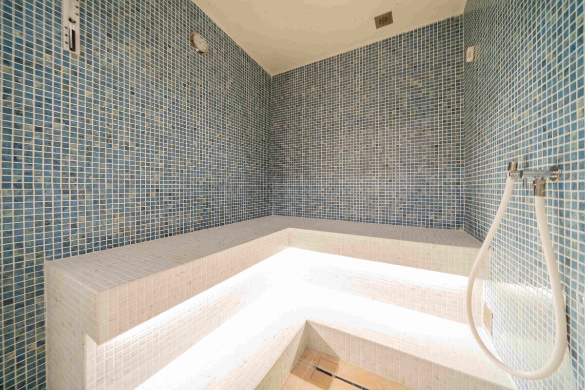 A bathroom with blue and white tiles and a shower head