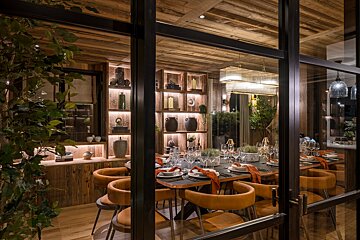 A dining room with a table and chairs and a glass door