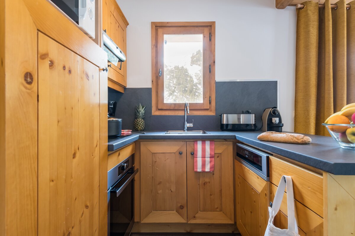 A kitchen with wooden cabinets and a bread loaf on the counter