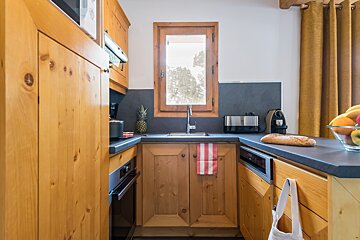 A kitchen with wooden cabinets and a bread loaf on the counter