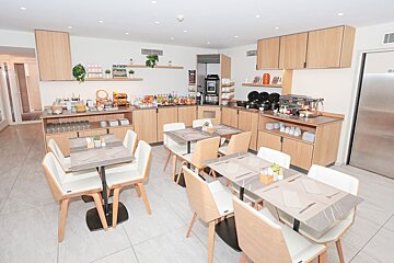 A dining room with tables and chairs and a buffet