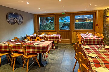 A restaurant with tables and chairs and a picture of a ski goggles on the wall