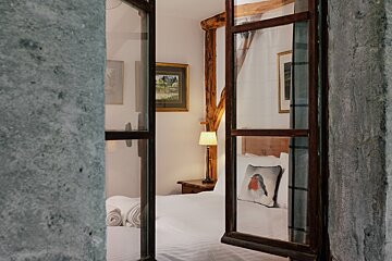 A bedroom with a canopy bed and a pillow with a bird on it