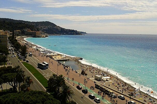 A beach with a lot of people and a green bike lane