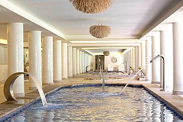 A swimming pool with a waterfall in the middle of it