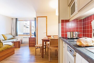 A kitchen with a pot on the stove and a loaf of bread on the counter