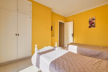 A bedroom with two beds and a picture on the wall